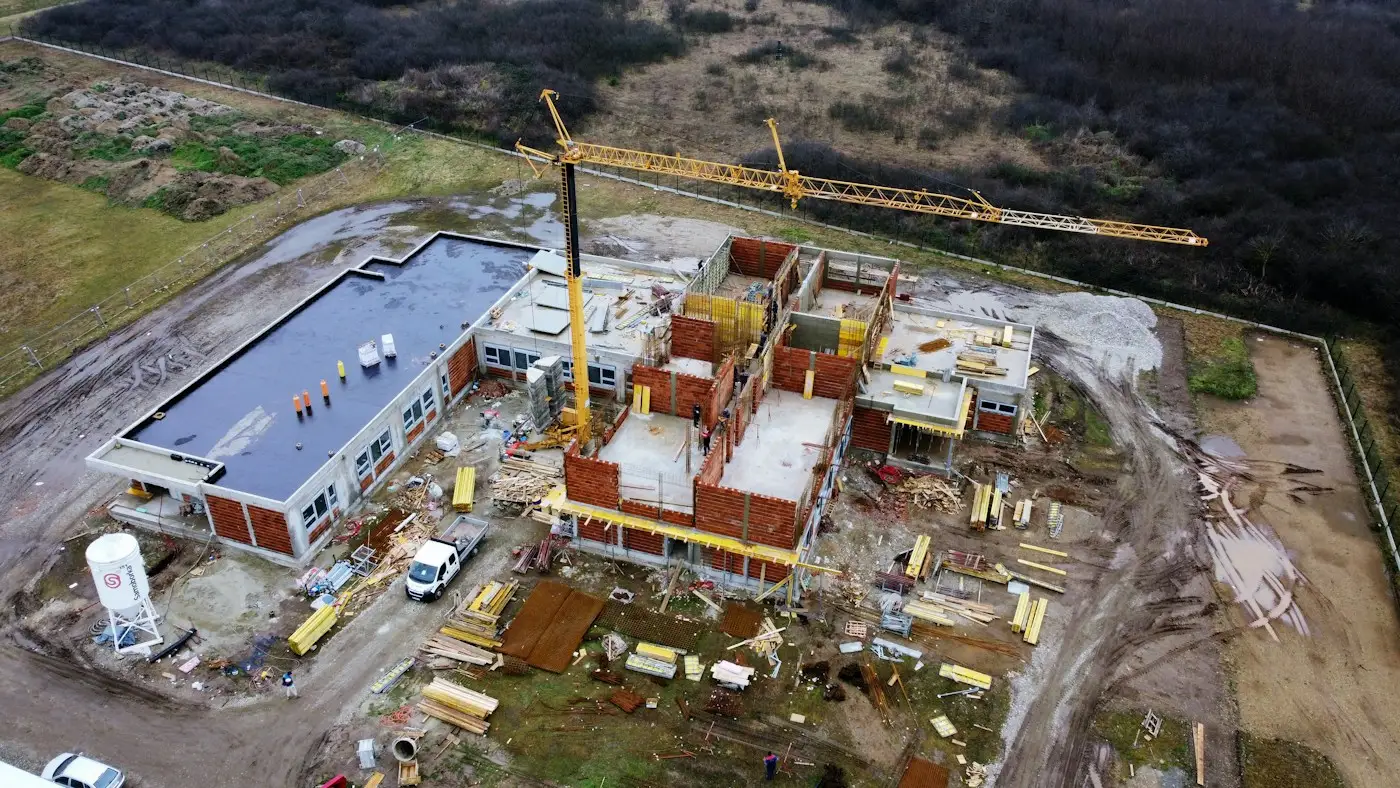 An aerial view of a school being built, with a tower crane beside it
