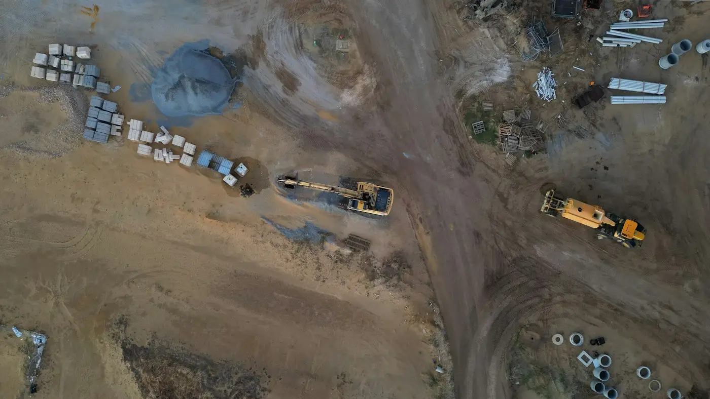 An aerial view of earthworks, with manhole rings and pipes laid out ready